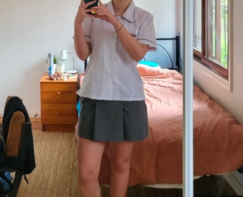 Carolina mit Schuluniform in ihrem Zimmer